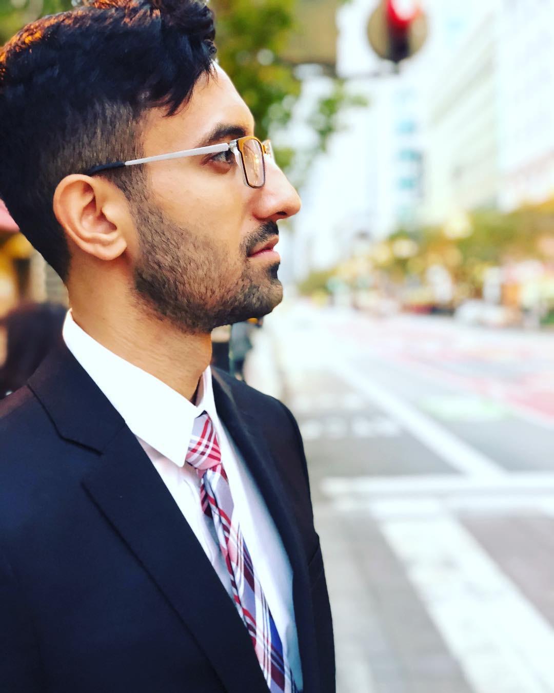 Anisur Khan standing on a city street, in profile